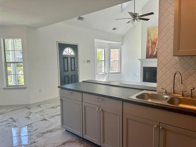 kitchen featuring ceiling fan, a healthy amount of sunlight, vaulted ceiling, and sink