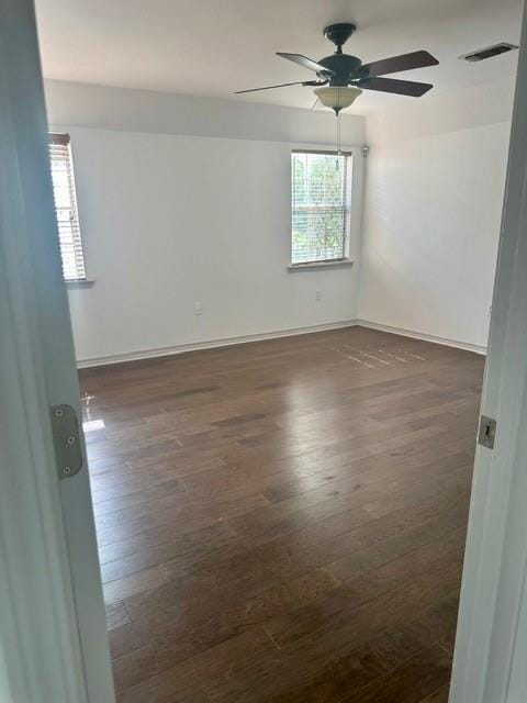 spare room featuring ceiling fan and dark hardwood / wood-style flooring