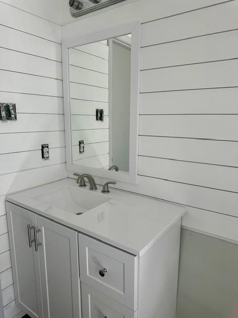 bathroom with vanity and wood walls