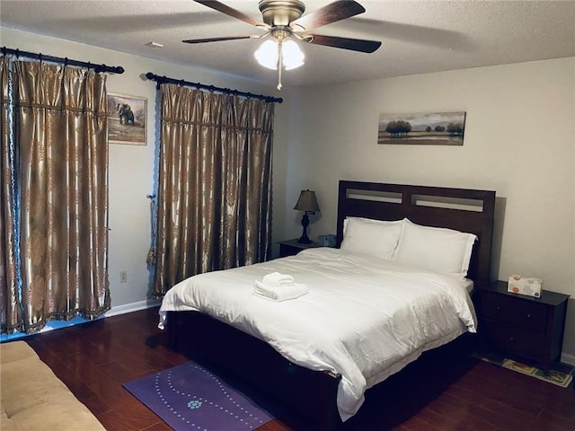 bedroom featuring ceiling fan, a textured ceiling, and dark hardwood / wood-style flooring