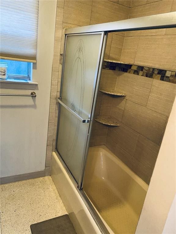 bathroom featuring bath / shower combo with glass door