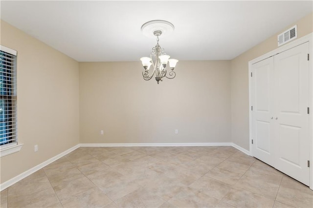 empty room featuring a chandelier