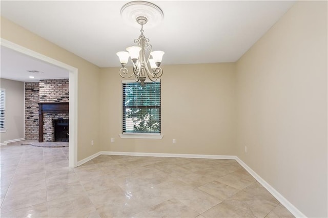 unfurnished dining area with a brick fireplace and an inviting chandelier