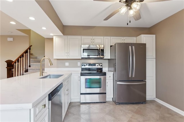 kitchen featuring appliances with stainless steel finishes, kitchen peninsula, white cabinets, and sink