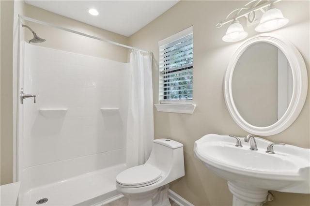 bathroom featuring sink, a shower with shower curtain, and toilet