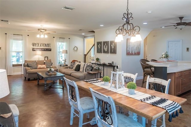 dining space featuring ceiling fan with notable chandelier and ornamental molding