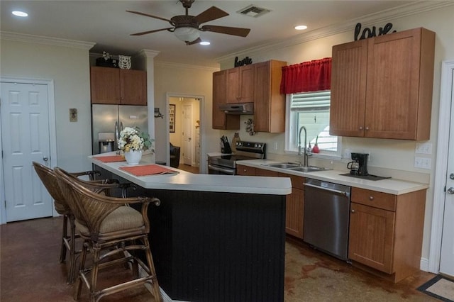 kitchen with a breakfast bar, stainless steel appliances, crown molding, sink, and a kitchen island