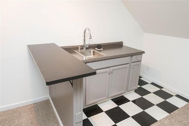 kitchen featuring a breakfast bar, gray cabinets, kitchen peninsula, and sink