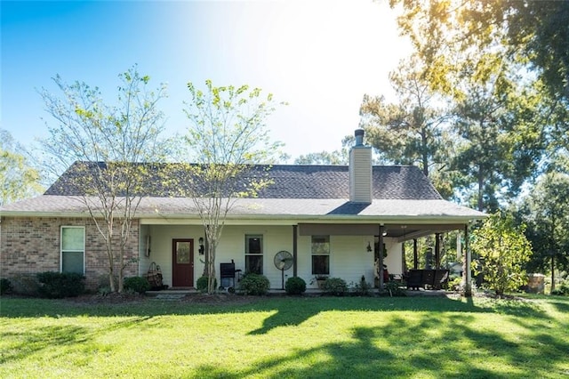 rear view of property with a lawn