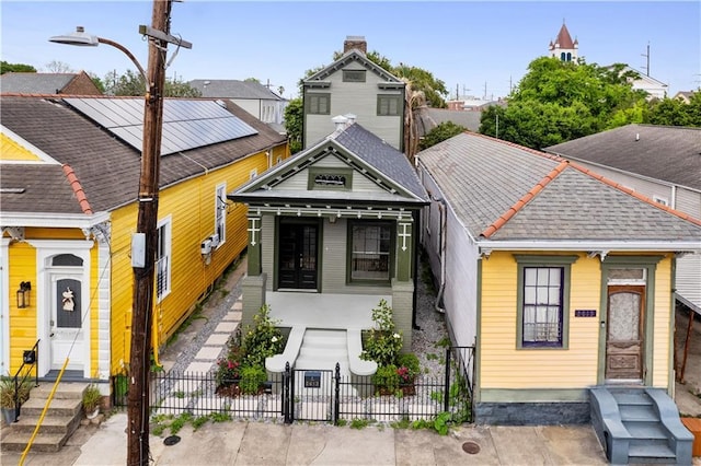 view of front facade featuring a fenced front yard, a gate, and a shingled roof