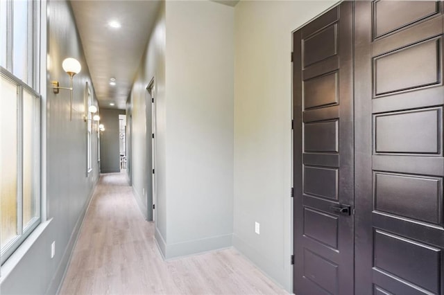 hallway featuring light wood-style floors, recessed lighting, and baseboards