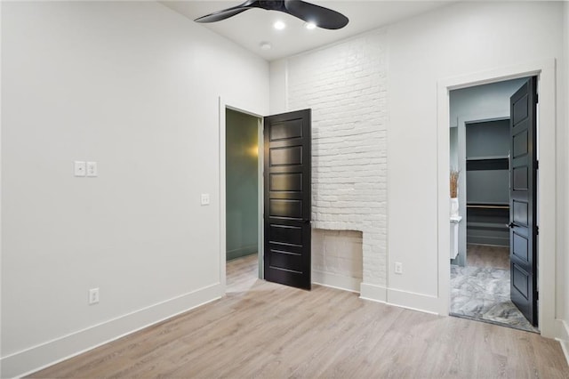 unfurnished bedroom with a ceiling fan, connected bathroom, baseboards, and wood finished floors