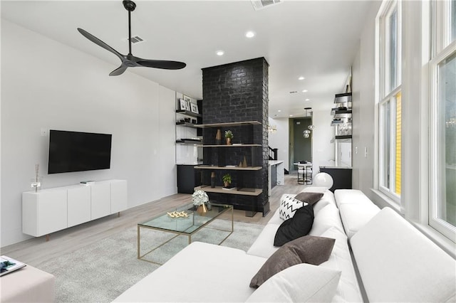 living room featuring recessed lighting, wood finished floors, visible vents, and a healthy amount of sunlight