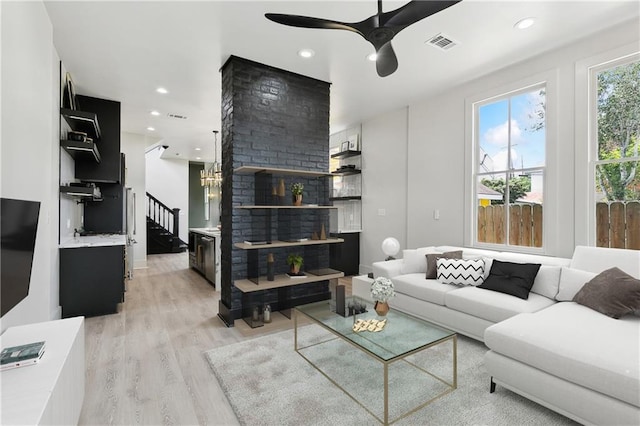 living area with light wood finished floors, recessed lighting, visible vents, stairway, and a ceiling fan