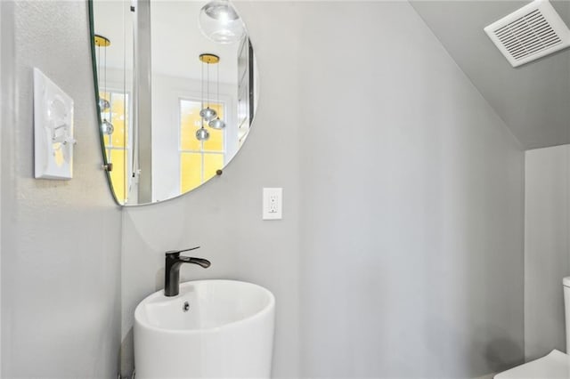 bathroom featuring visible vents, a sink, and toilet