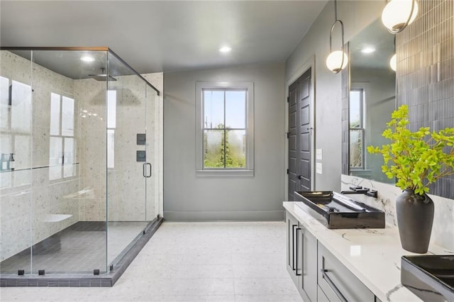 full bath featuring double vanity, recessed lighting, a shower stall, and baseboards