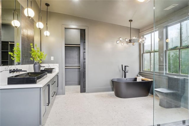 full bathroom featuring double vanity, tasteful backsplash, baseboards, a soaking tub, and a sink