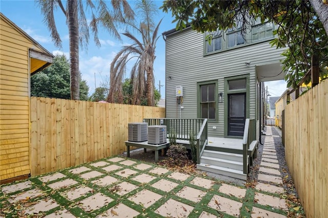 exterior space featuring central air condition unit, a fenced backyard, and a deck