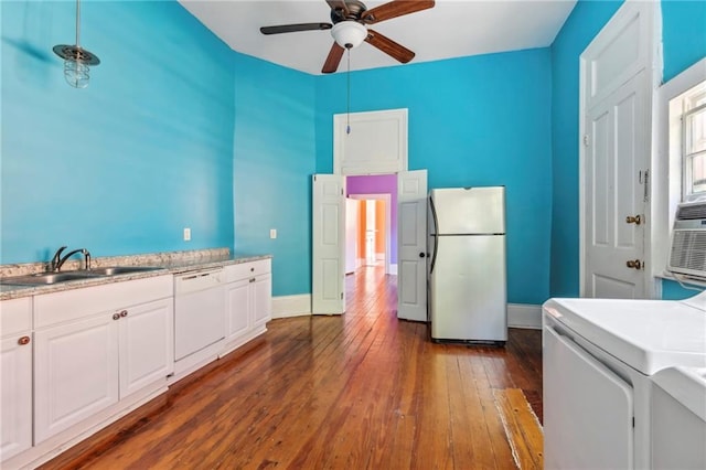 kitchen with dark hardwood / wood-style floors, washer / clothes dryer, sink, white cabinetry, and white appliances