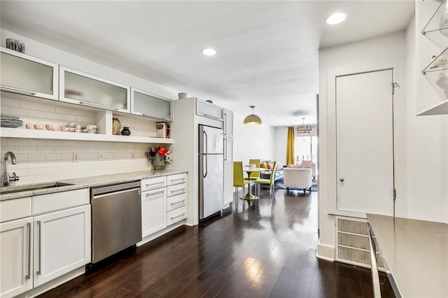 kitchen with white cabinets, hanging light fixtures, dark hardwood / wood-style floors, sink, and stainless steel appliances