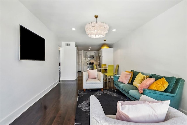 living room with a notable chandelier and dark wood-type flooring