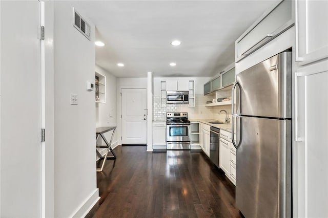 kitchen with dark wood-type flooring, appliances with stainless steel finishes, sink, and white cabinets