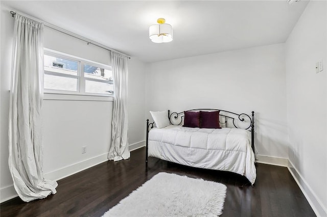 bedroom with dark hardwood / wood-style floors