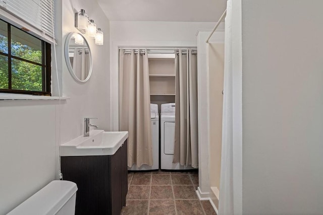 bathroom with toilet, washer and dryer, walk in shower, and vanity