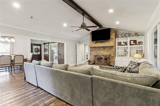 living room featuring a stone fireplace, ornamental molding, hardwood / wood-style floors, lofted ceiling with beams, and ceiling fan