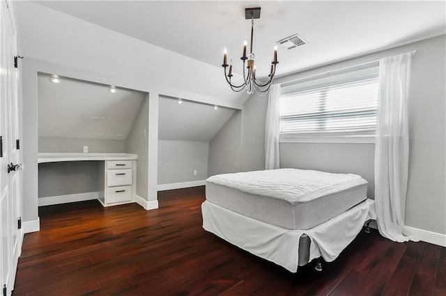 bedroom with dark wood-type flooring, vaulted ceiling, and a chandelier