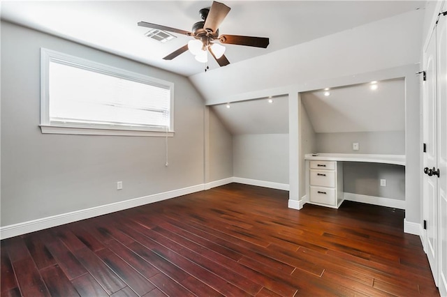 bonus room with built in desk, ceiling fan, lofted ceiling, and dark hardwood / wood-style flooring