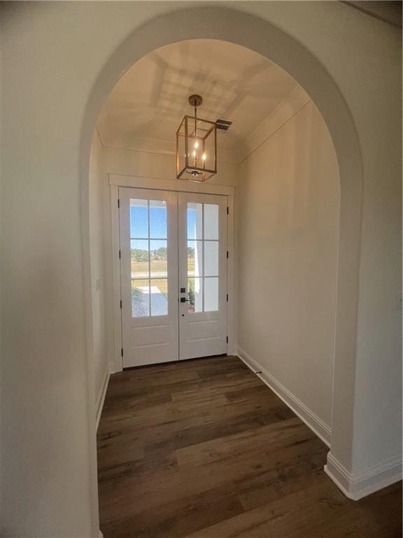 doorway featuring french doors, a chandelier, crown molding, and dark hardwood / wood-style flooring