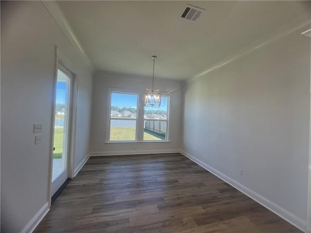 unfurnished dining area featuring an inviting chandelier, crown molding, dark wood-type flooring, and a water view