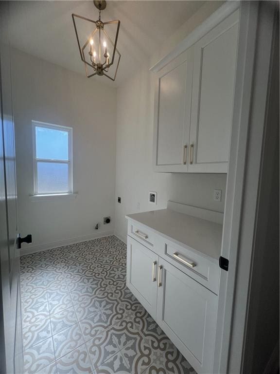 laundry room featuring hookup for a washing machine, light tile patterned flooring, electric dryer hookup, cabinets, and a chandelier