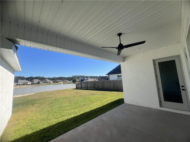 view of yard with a patio area, a water view, and ceiling fan