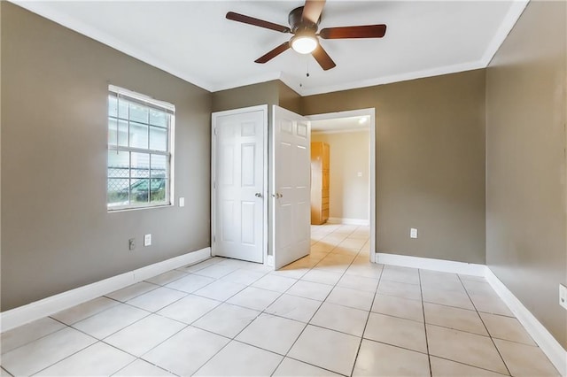 unfurnished bedroom with ornamental molding, light tile patterned floors, and ceiling fan