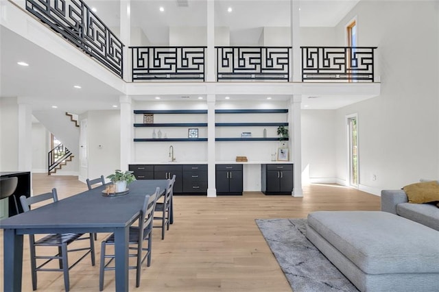 dining room featuring wood-type flooring and a high ceiling