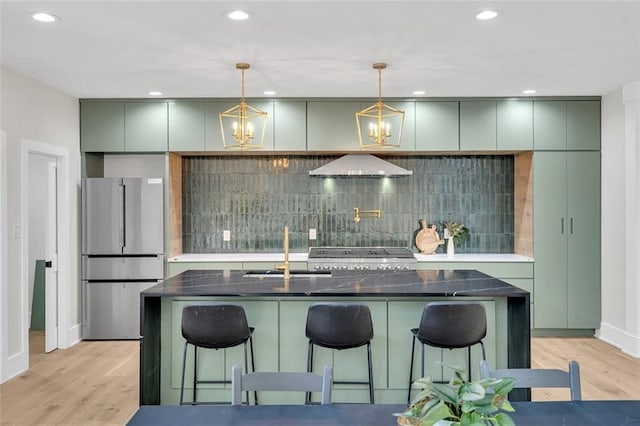 kitchen with stainless steel appliances, range hood, sink, a kitchen bar, and light wood-type flooring