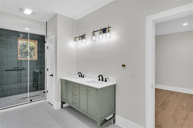 bathroom with vanity, hardwood / wood-style flooring, and a tile shower