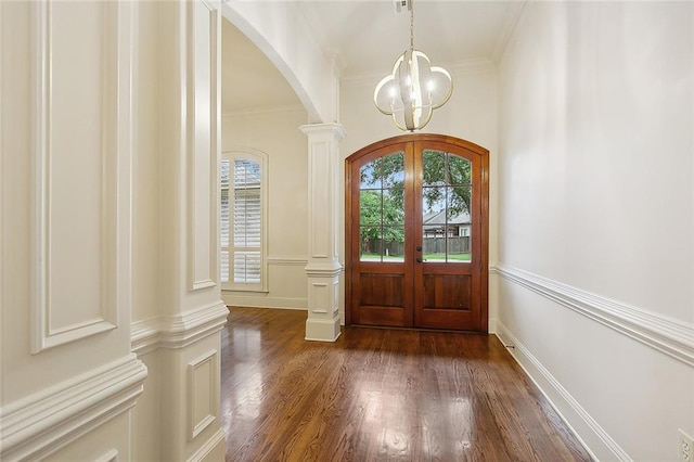 foyer entrance featuring dark wood-type flooring, ornate columns, crown molding, and french doors