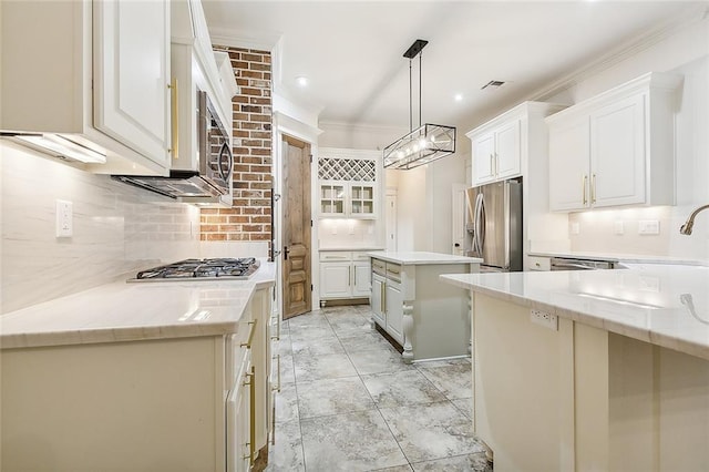 kitchen featuring white cabinetry, a center island, ornamental molding, stainless steel appliances, and decorative light fixtures