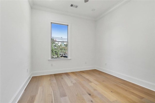 empty room featuring ornamental molding and light hardwood / wood-style flooring