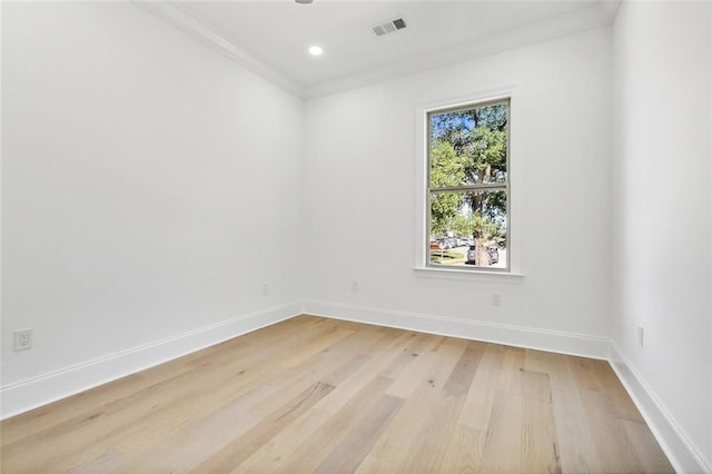 unfurnished room with crown molding and light wood-type flooring