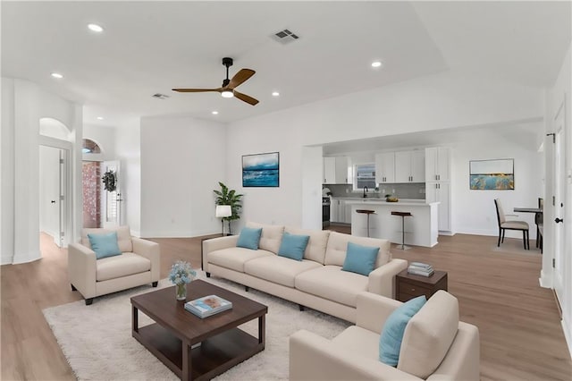 unfurnished living room with ceiling fan, lofted ceiling, and light hardwood / wood-style flooring