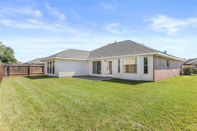 back of property with a yard and a patio