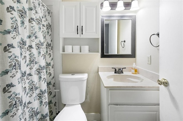 bathroom featuring vanity, toilet, and curtained shower