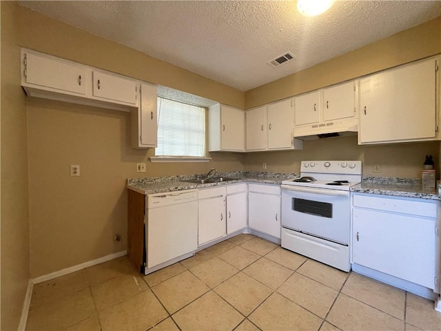 kitchen with white appliances, light tile patterned flooring, sink, a textured ceiling, and white cabinets