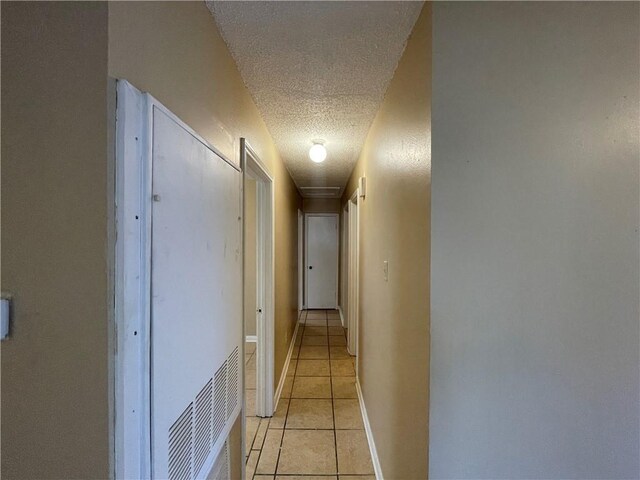 1023 Hendee St, New Orleans, LA 70114 - corridor featuring a textured ceiling, baseboards, and light tile patterned floors