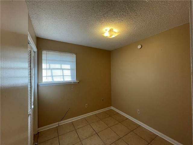 tiled spare room with a textured ceiling