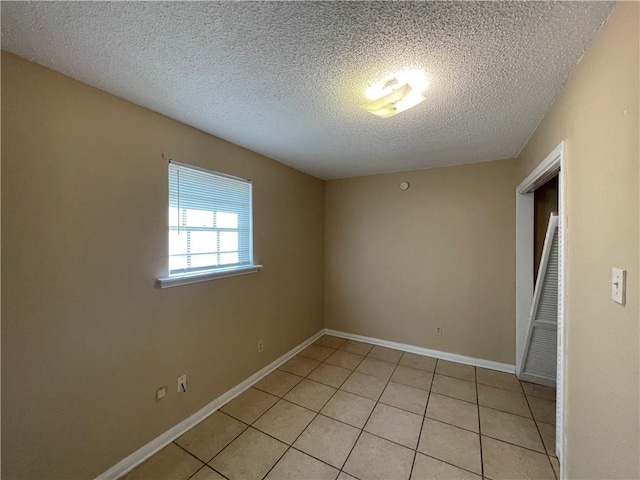 tiled spare room with a textured ceiling